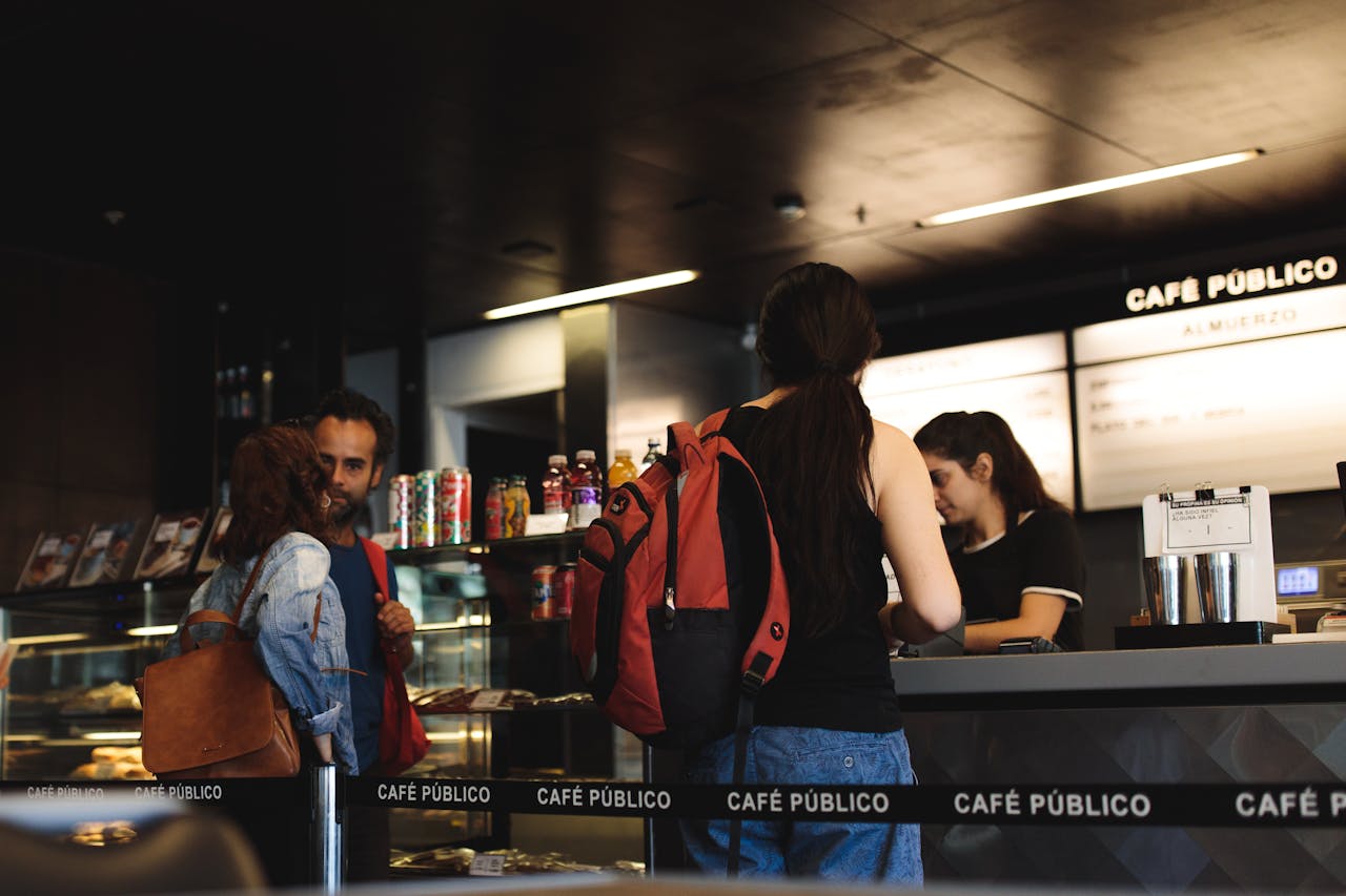 why-choose-us Young adults interacting at a modern café counter, ordering and conversing.